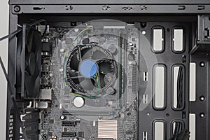 Building of PC, ATX motherboard inserted to black computer midi