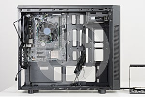 Building of PC, ATX motherboard inserted to black computer midi