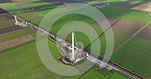 Building process of wind turbine windmill construction with cranes. Parts of the wind turbine, housing, hub, blades on