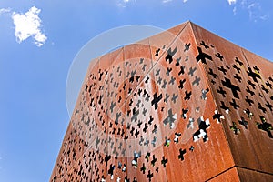 A building with raw metal walls covered with rust, cut out shapes of crosses. photo