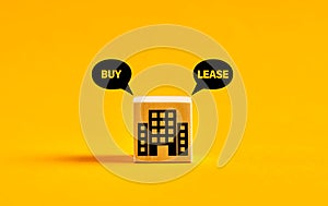 Building or real estate icon on wooden cube with buy or lease choice. Buying or leasing dilemma