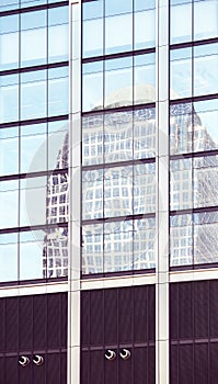 Building reflected in windows of a modern skyscraper, abstract urban background, color toning applied, New York City, USA