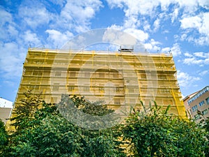 Building in reform with the facade covered by security mesh photo