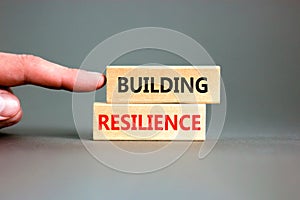 Building resilience symbol. Concept word Building resilience typed on wooden blocks. Beautiful grey table grey background.