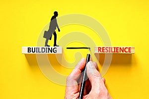 Building resilience symbol. Concept word Building resilience typed on wooden blocks. Beautiful yellow table yellow background.