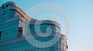 A building with rounded shapes and a glass facade against the sky.