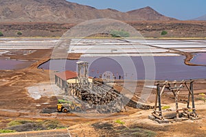 Building at Salinas de Pedra de Lume, old salt lakes with people swimming in the water on Sal Island, Cape Verde