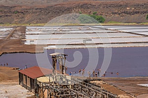 Building at Salinas de Pedra de Lume, old salt lakes with people swimming in the water on Sal Island, Cape Verde photo