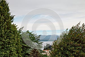 building on the shore in a thicket of trees, against the backdrop of a lake and mountains