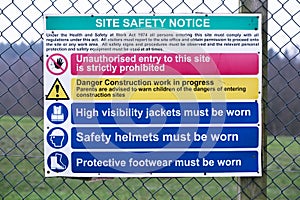 Building site construction safety notice sign on fence
