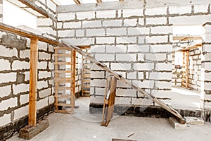 Building site of a house under construction. Unfinished house walls made from white aerated autoclaved concrete blocks.