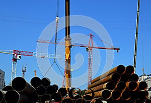 Building site with working lift cranes on a sunny day with clear blue sky
