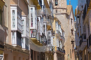 Building and street in Seville, Spain, details of old facade, wall with wooden frame windows.