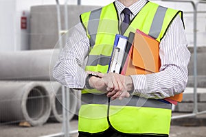 Building surveyor in high visibility checking the time on site