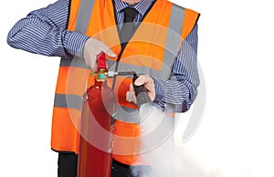 Building Surveyor in orange visibility vest using a fire extinguisher