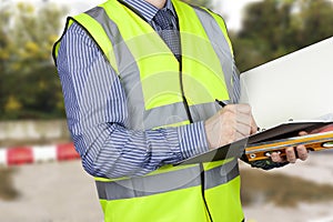 Building surveyor with sprit level writing notes in his folder