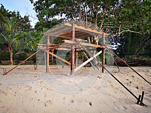 Building a tiny wooden house on the beach side.