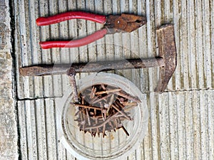 a building tool in the form of nails, hammer, and pliers