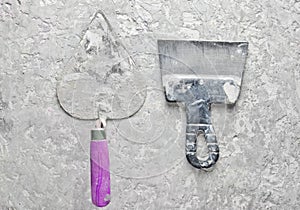 Building tools on a gray concrete background. Spatula, trowel, top view.