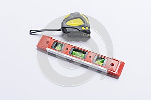 Building tools, rubber hammer, meter and bubble level on white background.