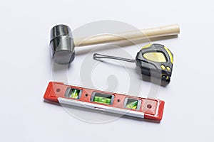 Building tools, rubber hammer, meter and bubble level on white background.