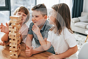 Building a tower. Playing game. Kids having fun in the domestic room at daytime together