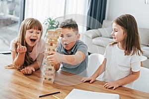 Building a tower. Playing game. Kids having fun in the domestic room at daytime together