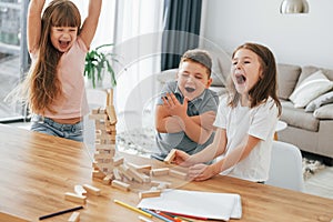 Building a tower. Playing game. Kids having fun in the domestic room at daytime together