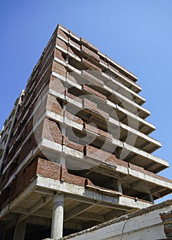 Building under construction against blue sky. General view of the construction of a new residential complex. Partially constructed