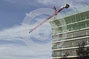 building under construction with crane and blue sky background