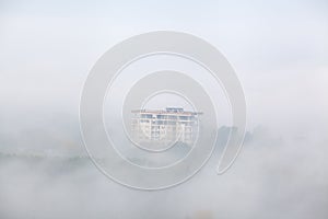 Building under construction in the fog with trees
