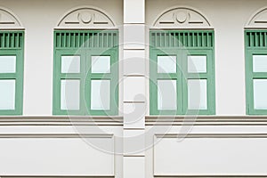 Building wall in classic style with green windows