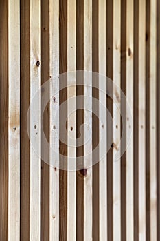 Building wall decorated with wooden furring on house terrace