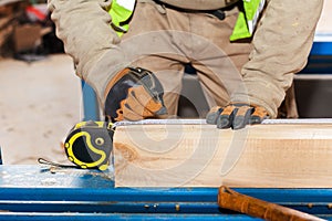 Building a wall for frame house. Worker make marks for cutting timber.