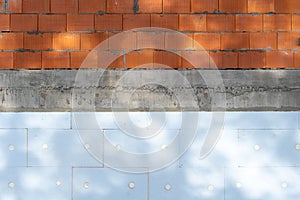 Building wall with red brick, panel blocks and styrofoam insulation material