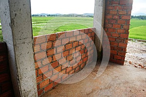 Building the walls of the house with red bricks. photo