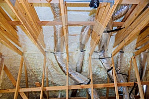 Building with wooden beams of a roof installing pipe heating system