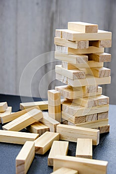 Building from wooden blocks. Game for family of wooden bars. Wood blocks stack game with Hand on background. Block tower