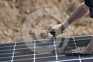 Building worker installing alternative energy photovoltaic solar panels on roof