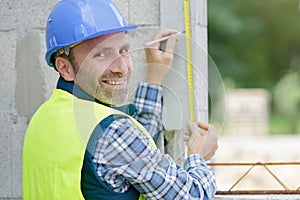 building worker measuring wall construction site