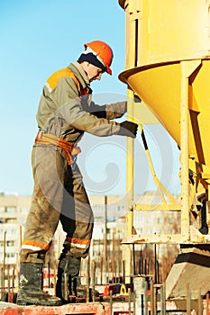 Building worker pouring concrete with barrel