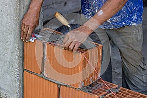 Building worker setting string line between clay block
