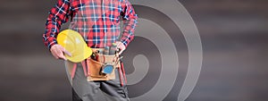 Building worker with tool belt and helmet