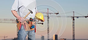 Building worker with tool belt and helmet