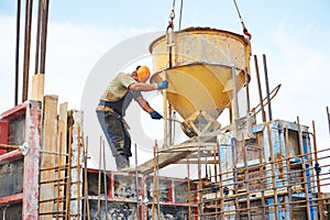 Building workers pouring concrete with barrel