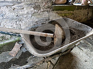 Building works, DIY. Mixing cement in a wheelbarrow.