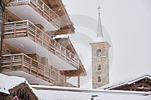 Buildings with balconies in French ski resort during snow falling in Winter. Accomodation, hotels