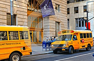 Buildings, classic architecture, yellow school bus with driver on the street in wall street in manhattan in new york
