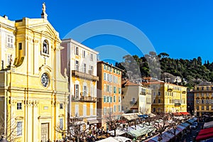 Buildings of Cours Saleya with trees on the background in Nice, France