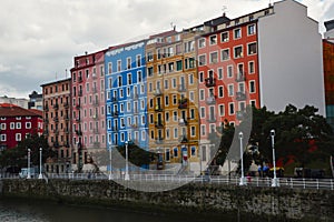 buildings of different colors next to rio Nervion in Bilbao, Spain photo